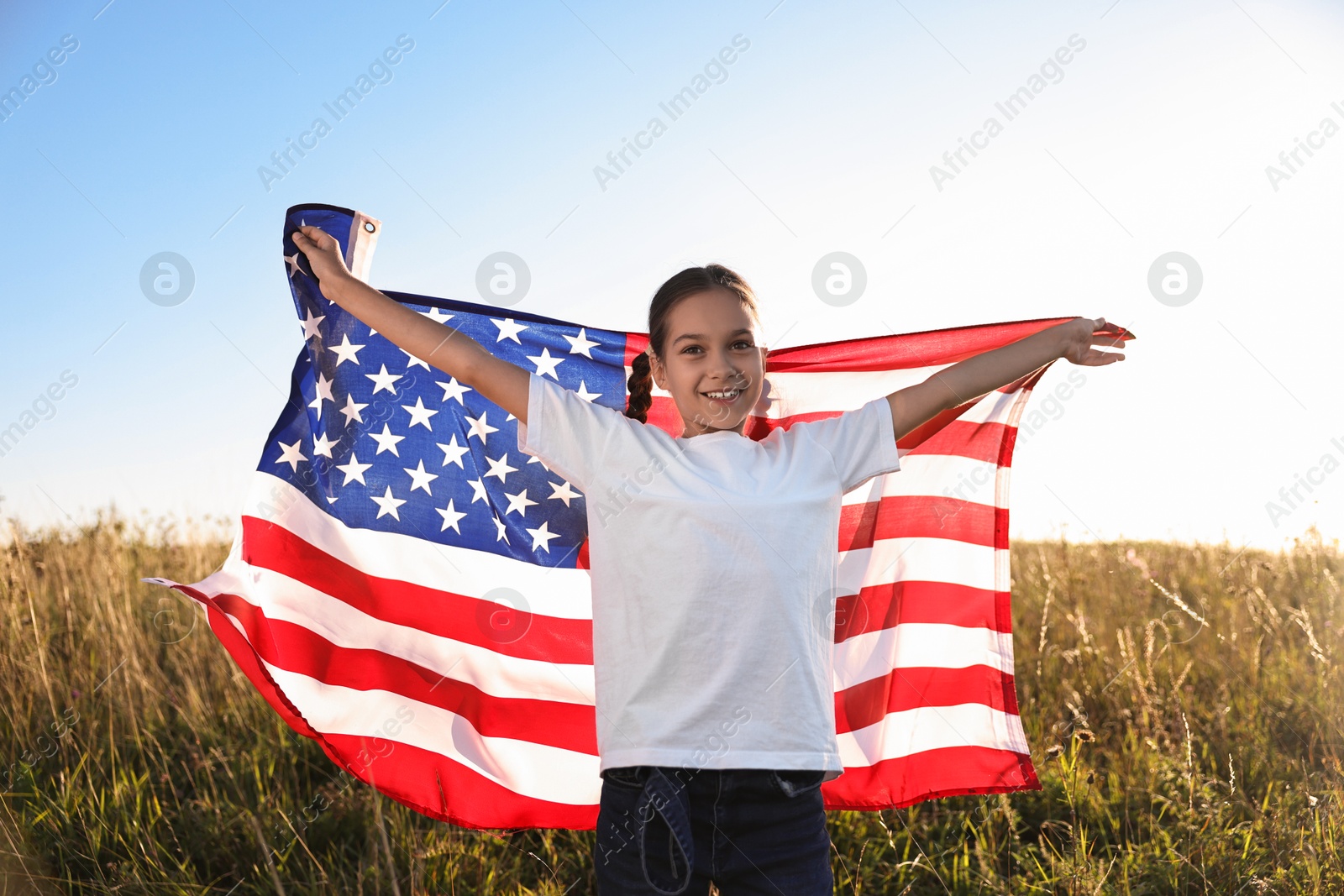 Photo of Happy girl with flag of USA outdoors