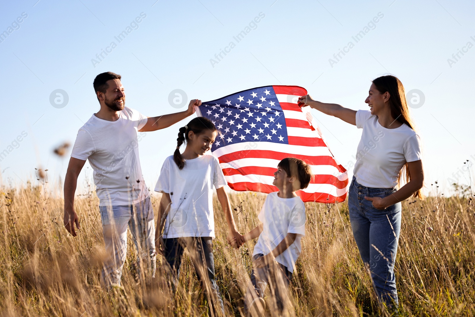 Photo of Happy family with flag of USA outdoors