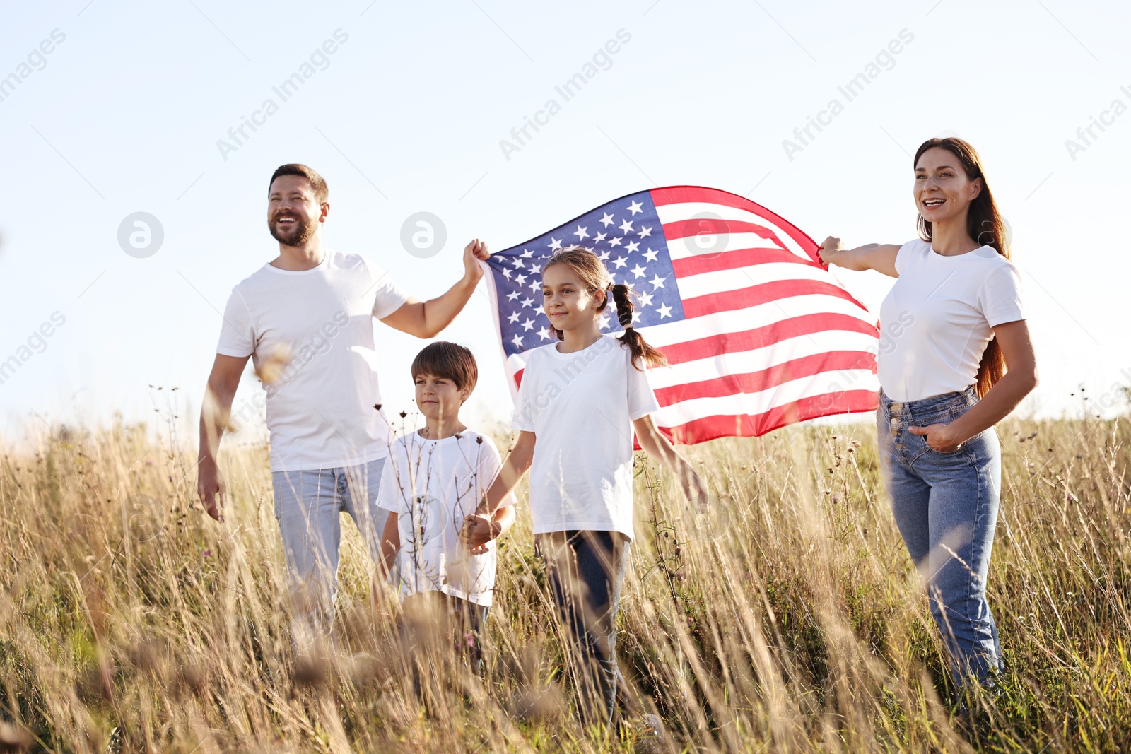 Photo of Happy family with flag of USA outdoors