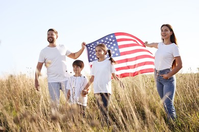 Photo of Happy family with flag of USA outdoors