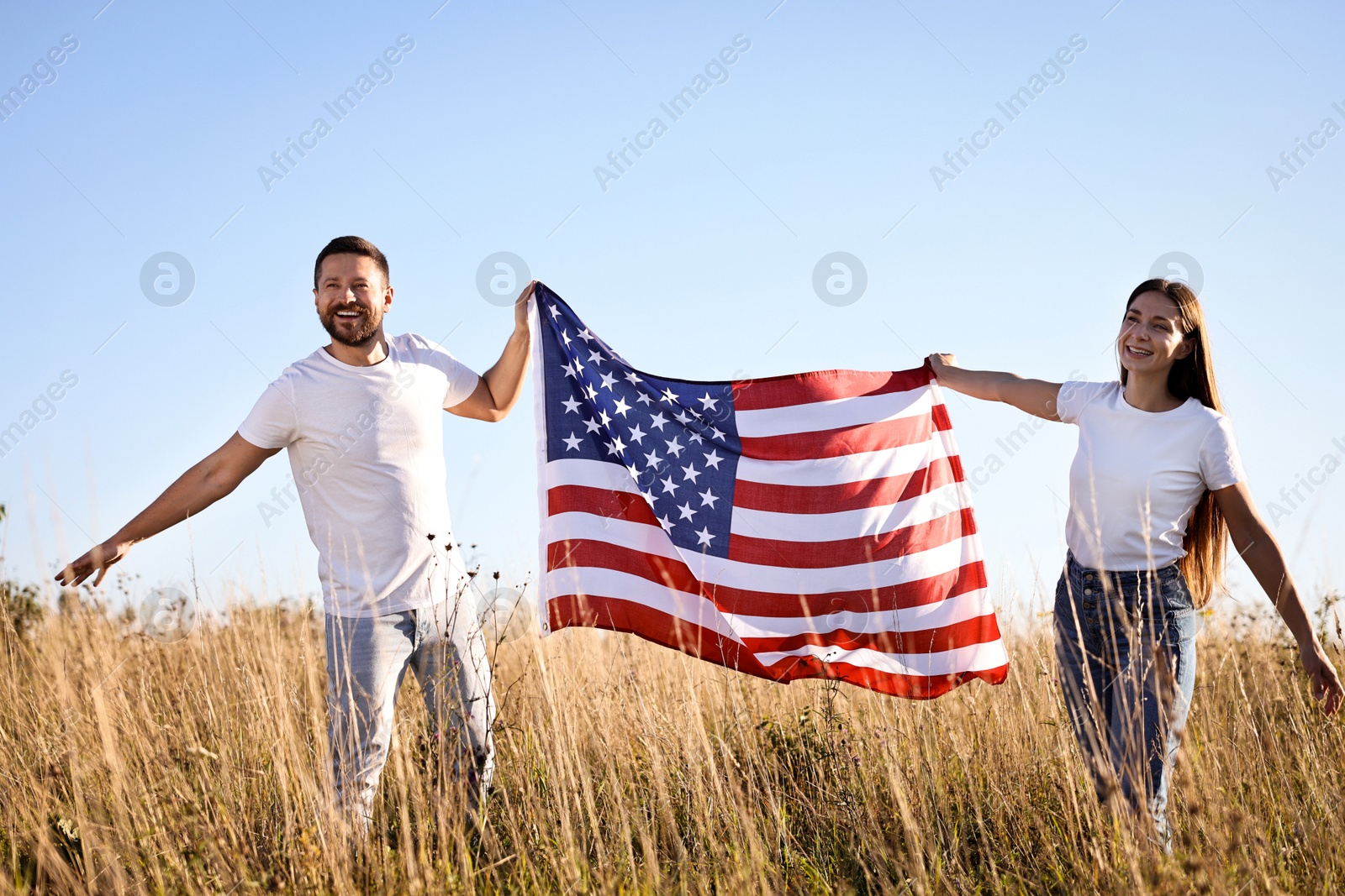 Photo of Happy couple with flag of USA outdoors