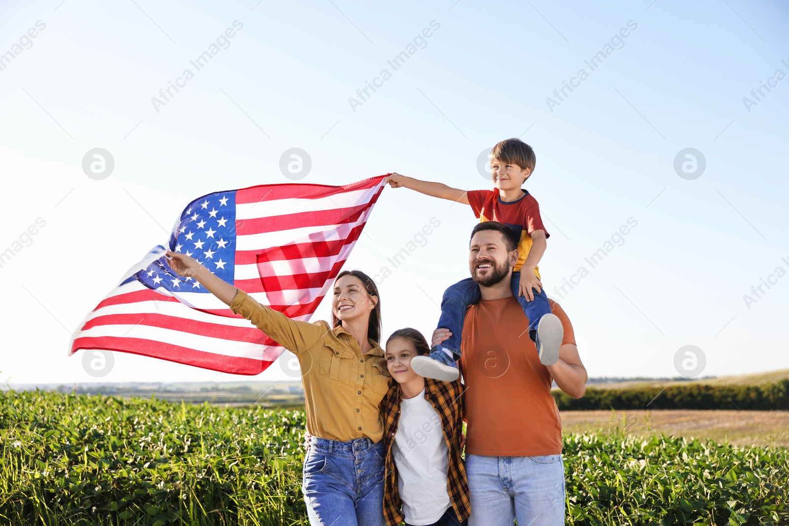 Photo of Happy family with flag of USA outdoors