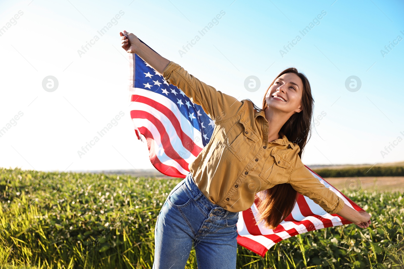 Photo of Happy woman with flag of USA outdoors. Space for text