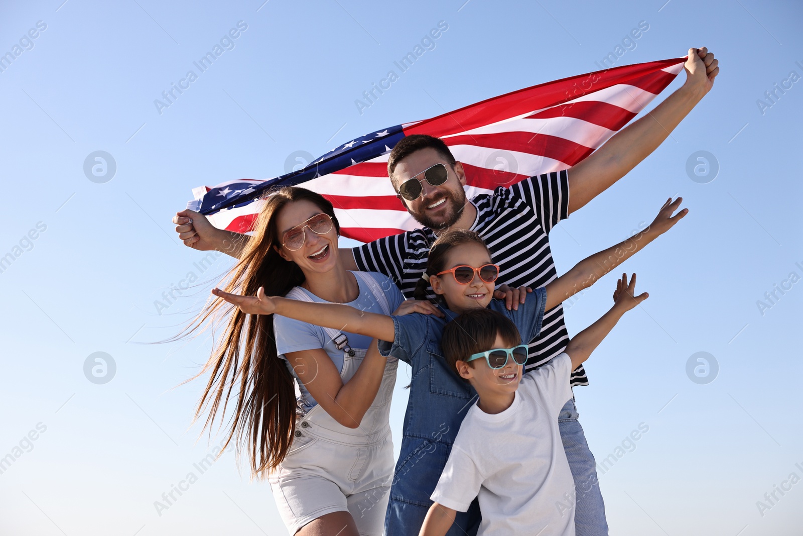 Photo of Happy family with flag of USA outdoors