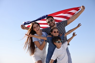 Photo of Happy family with flag of USA outdoors