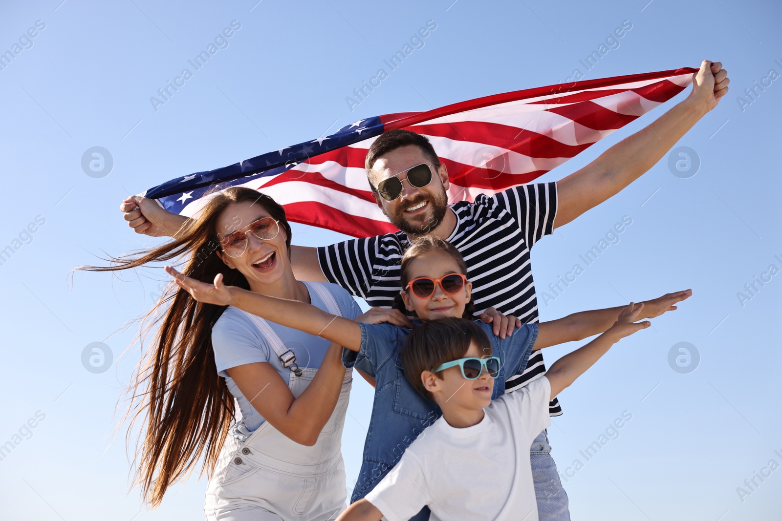 Photo of Happy family with flag of USA outdoors