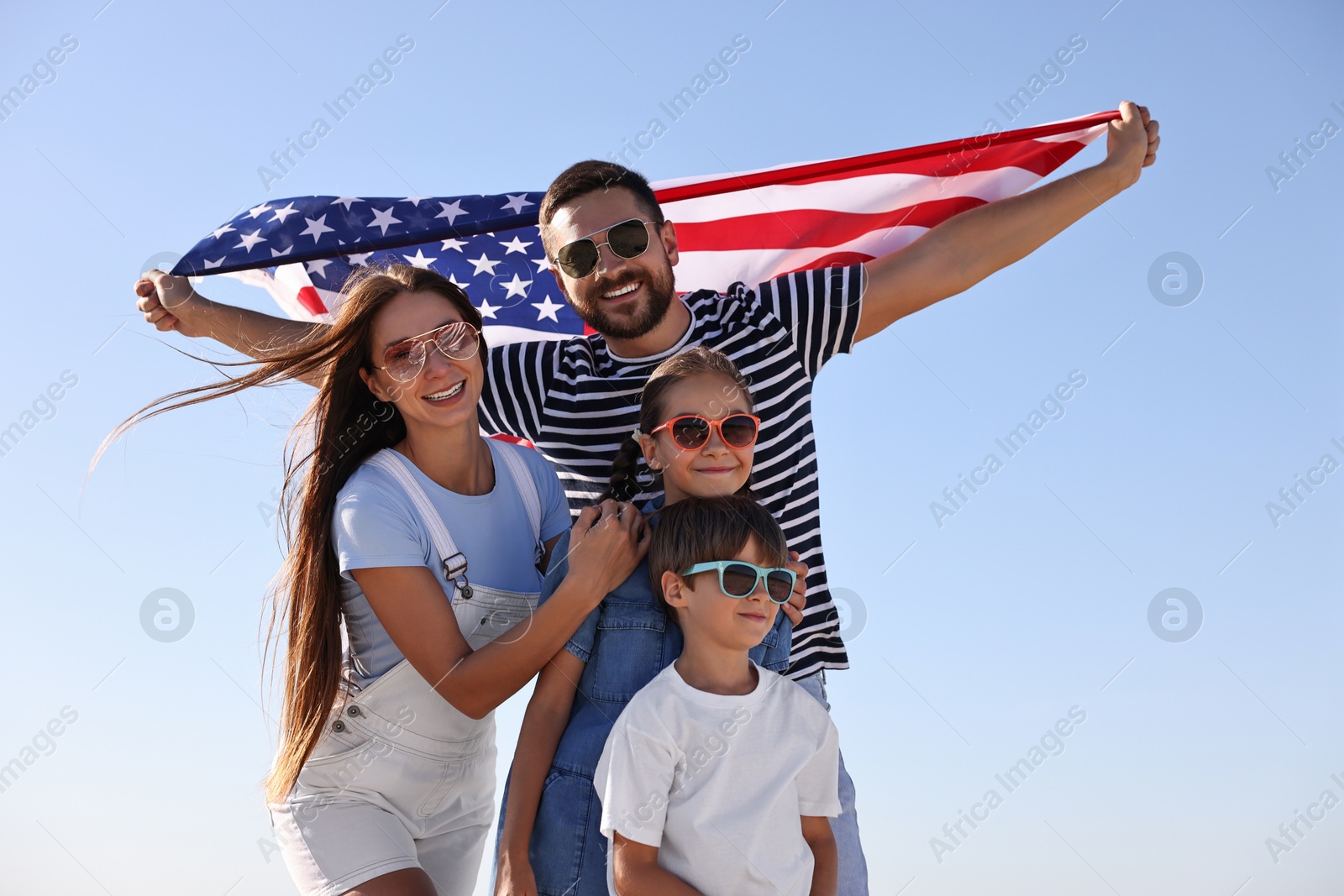 Photo of Happy family with flag of USA outdoors