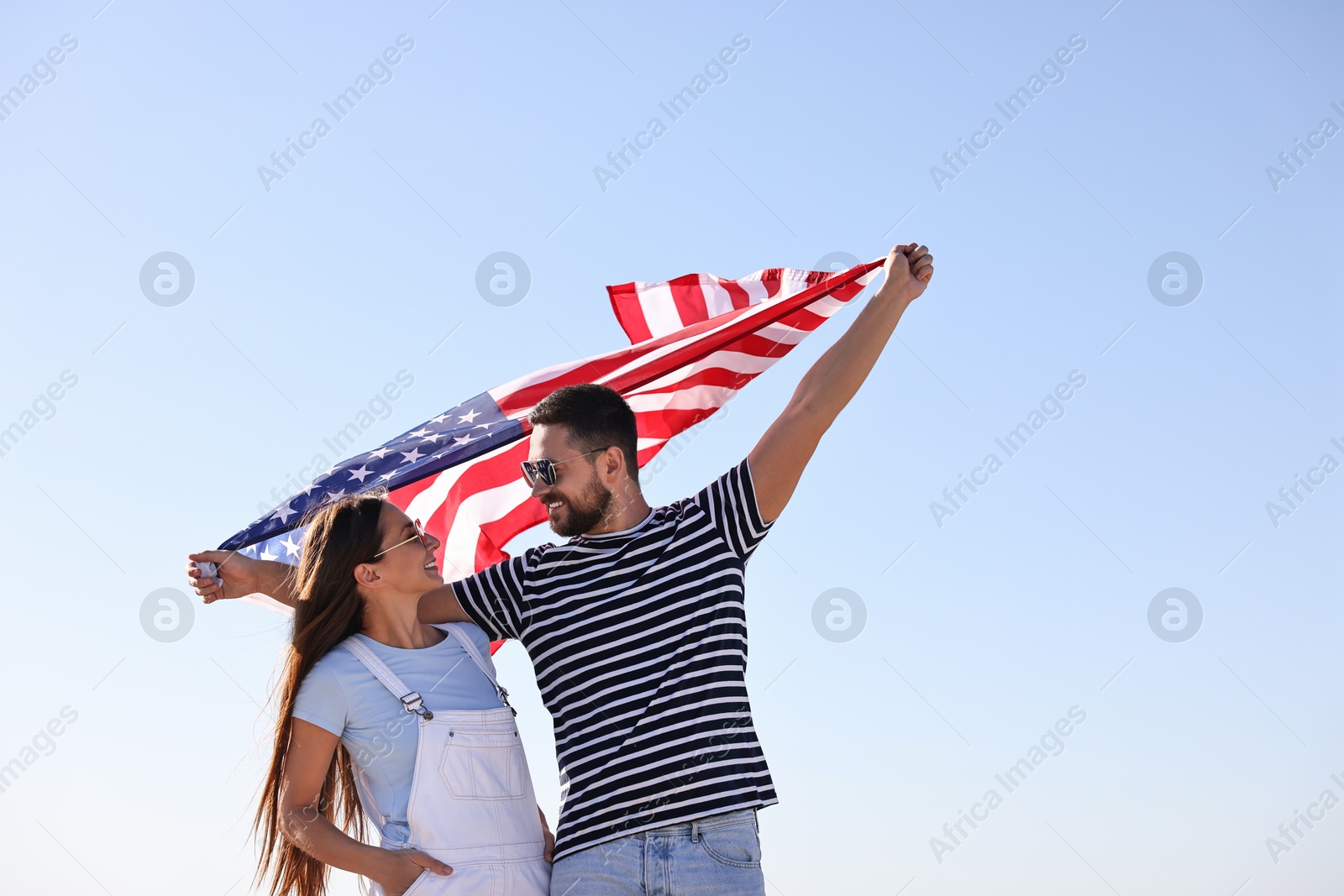 Photo of Happy couple with flag of USA outdoors