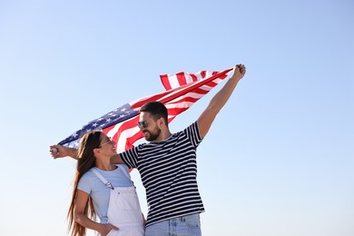 Happy couple with flag of USA outdoors