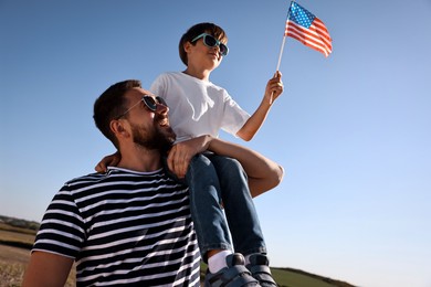 Photo of Happy father and son with flag of USA outdoors