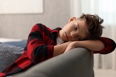 Photo of Loneliness concept. Sad teenage boy on sofa in room