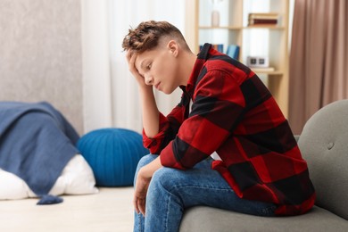 Photo of Loneliness concept. Sad teenage boy on sofa at home