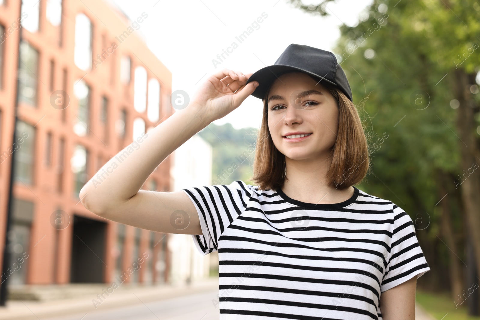 Photo of Portrait of smiling woman in baseball cap outdoors