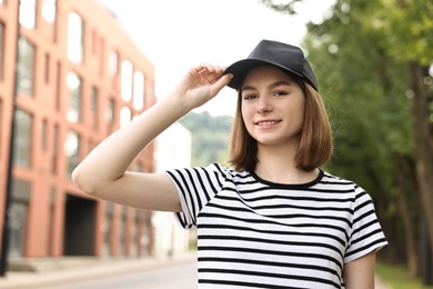 Portrait of smiling woman in baseball cap outdoors