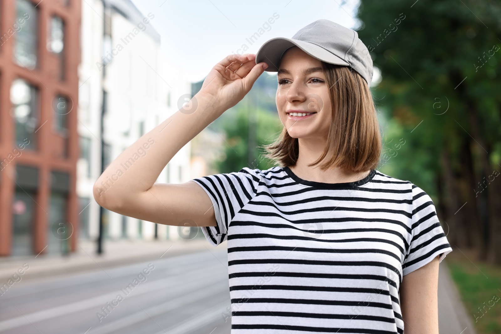 Photo of Portrait of smiling woman in baseball cap outdoors