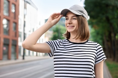 Portrait of smiling woman in baseball cap outdoors