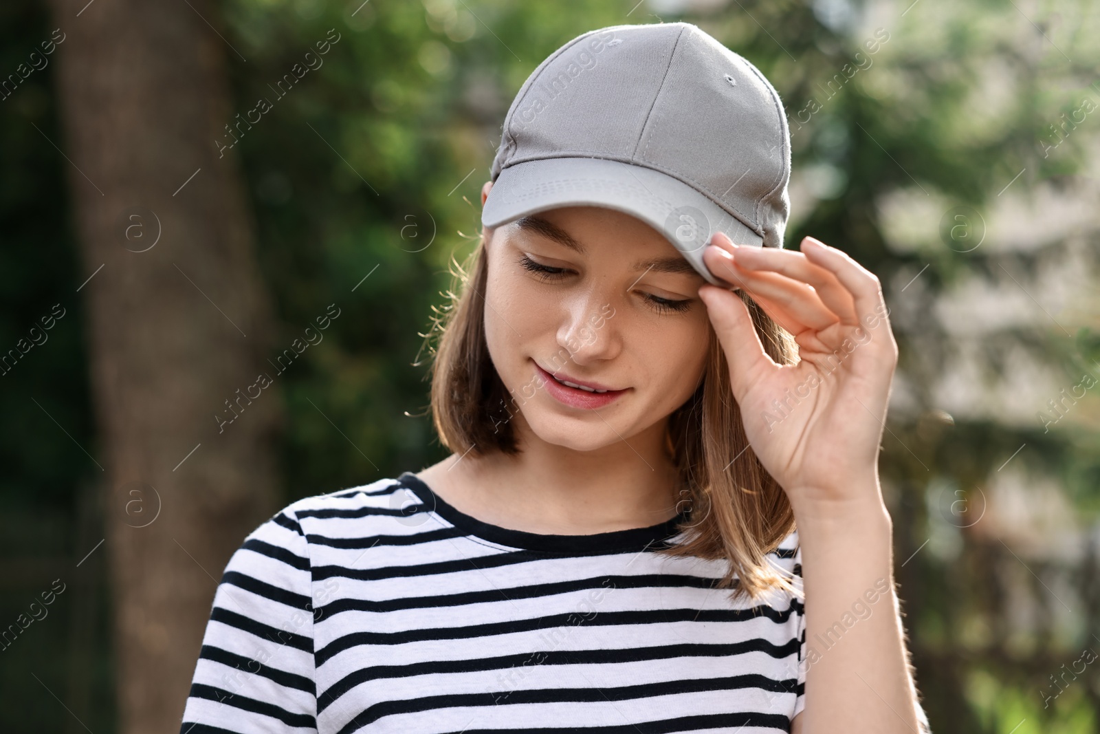 Photo of Portrait of smiling woman in baseball cap outdoors