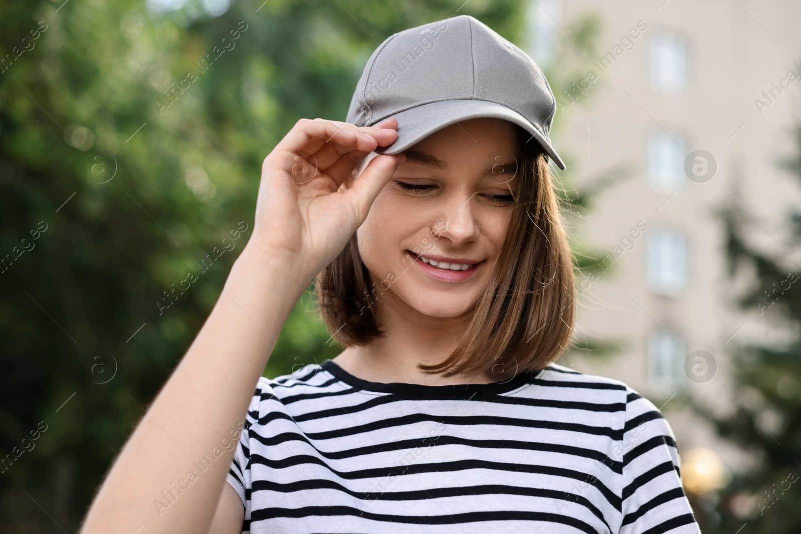 Photo of Portrait of smiling woman in baseball cap outdoors