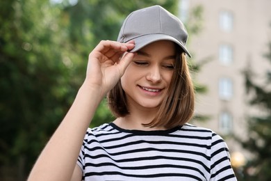 Portrait of smiling woman in baseball cap outdoors