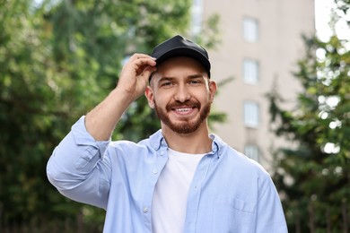 Photo of Portrait of smiling man in baseball cap outdoors