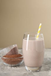 Photo of Delicious protein shake in glass and powder on grey table