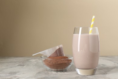 Photo of Delicious protein shake in glass and powder on grey table