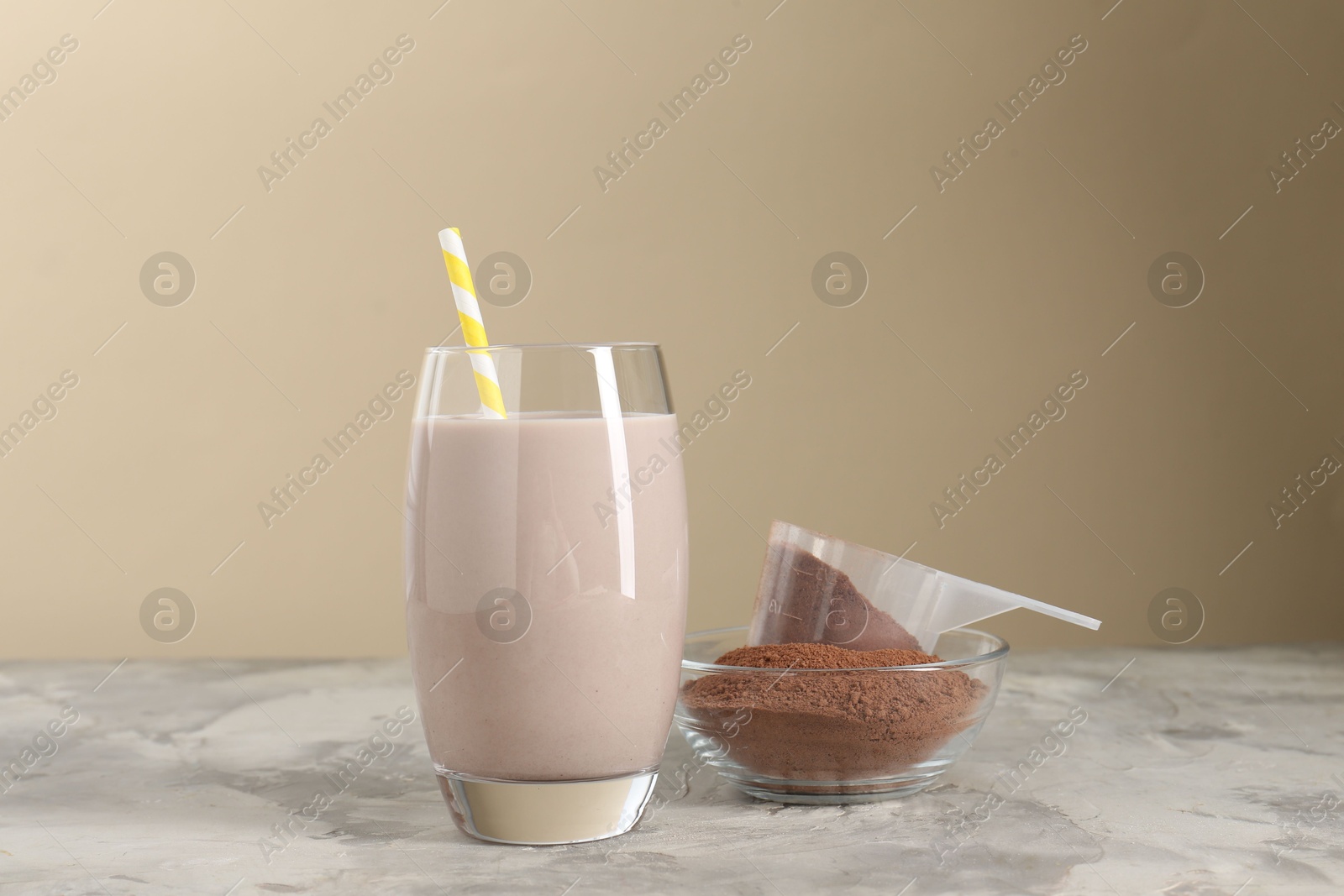 Photo of Delicious protein shake in glass and powder on grey table