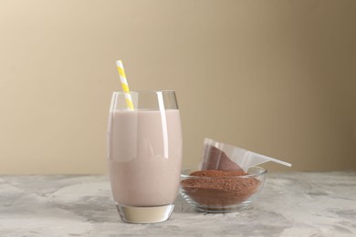 Photo of Delicious protein shake in glass and powder on grey table