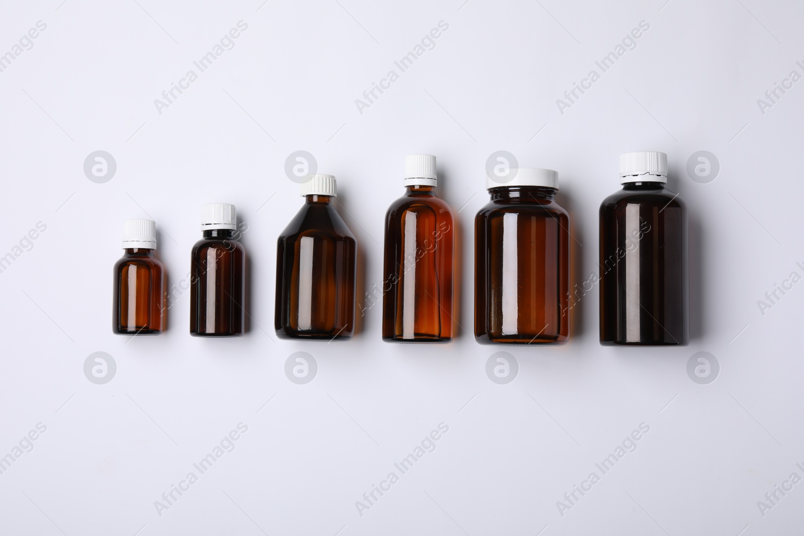 Photo of Medical bottles with medicine on white background, top view