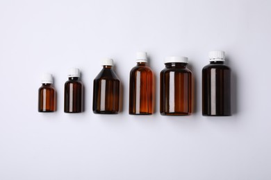 Photo of Medical bottles with medicine on white background, top view