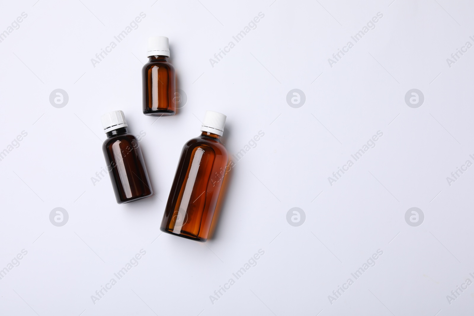 Photo of Medical bottles with medicine on white background, top view. Space for text