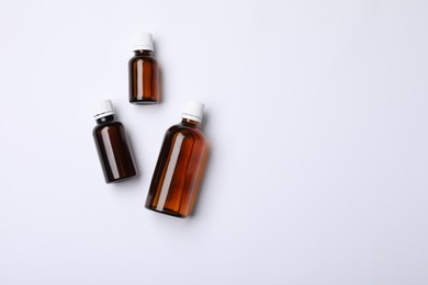 Photo of Medical bottles with medicine on white background, top view. Space for text