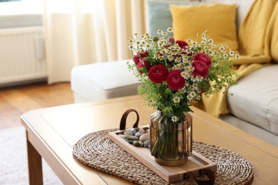 Photo of Beautiful ranunculus flowers and chamomiles in vase on table indoors. Space for text