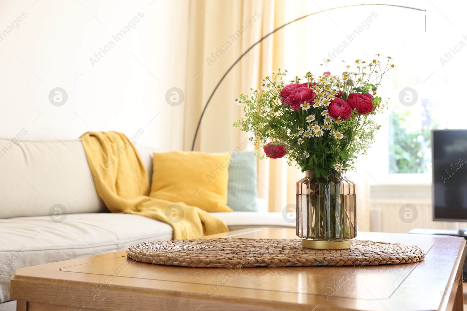 Photo of Beautiful ranunculus flowers and chamomiles in vase on table indoors. Space for text