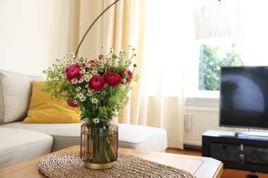 Photo of Beautiful ranunculus flowers and chamomiles in vase on table indoors