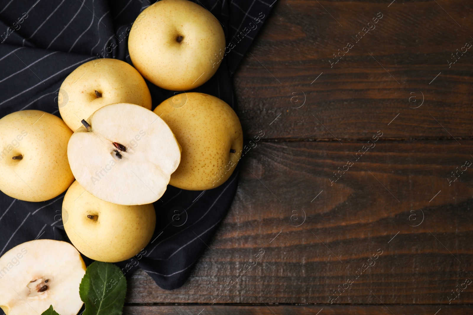 Photo of Delicious fresh apple pears and leaf on wooden table, top view. Space for text