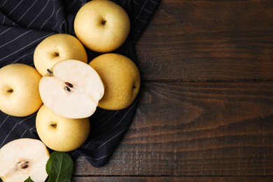 Photo of Delicious fresh apple pears and leaf on wooden table, top view. Space for text