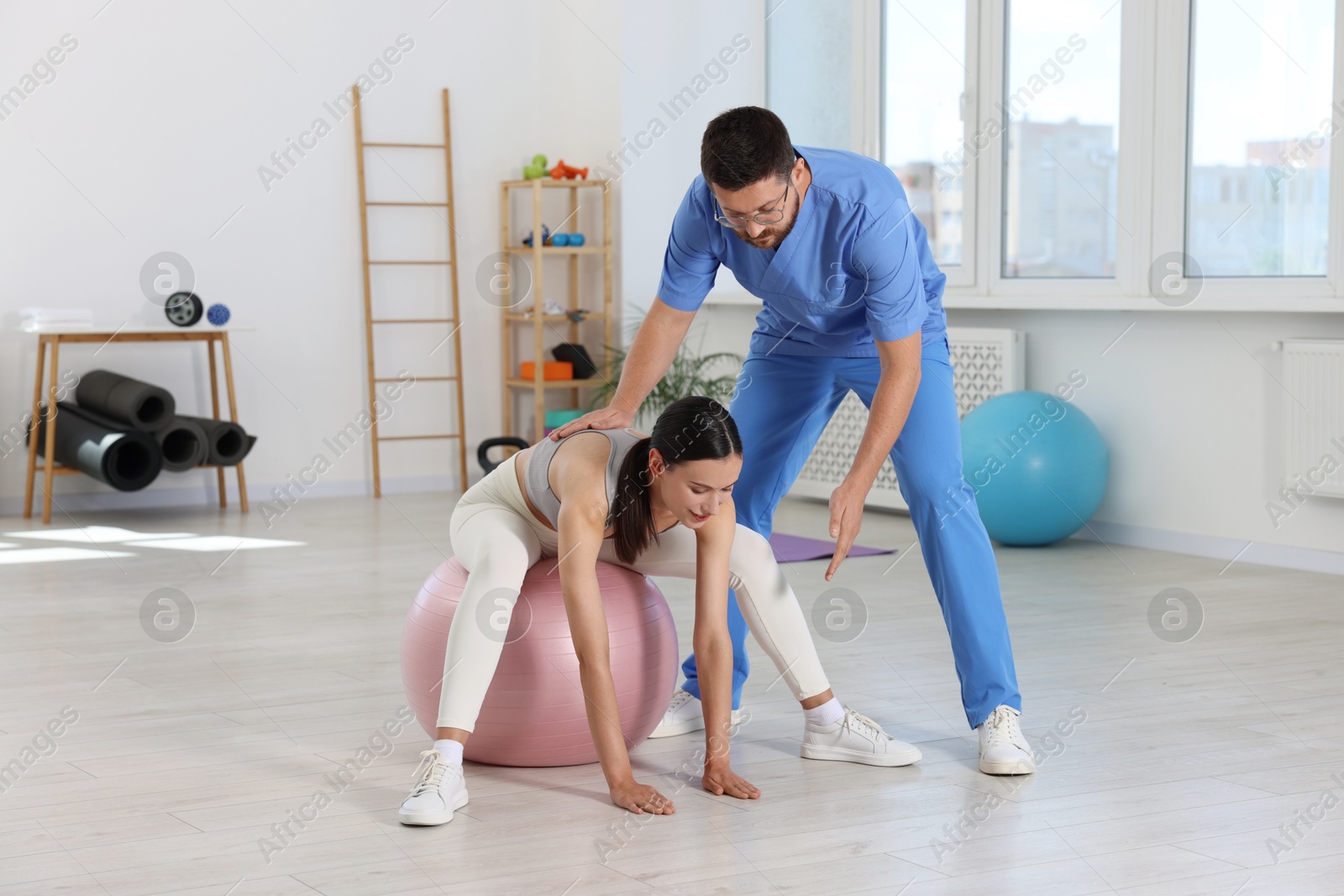 Photo of Physiotherapist working with patient in rehabilitation center