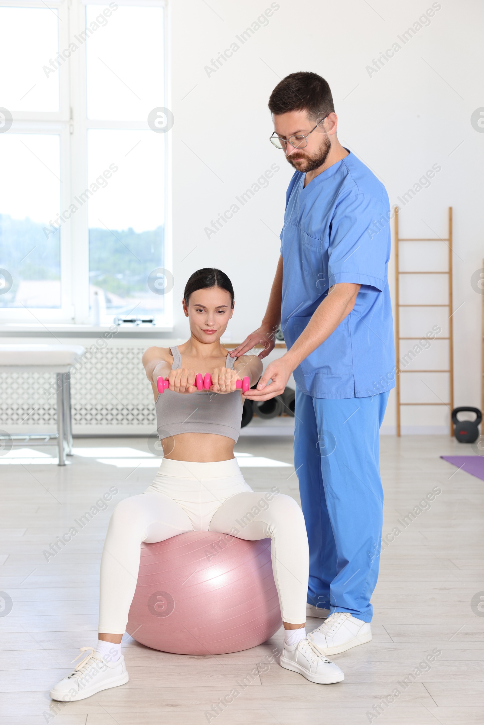 Photo of Patient exercising under physiotherapist supervision in rehabilitation center