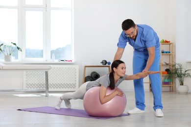 Photo of Physiotherapist working with patient in rehabilitation center