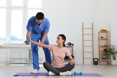 Patient exercising under physiotherapist supervision in rehabilitation center