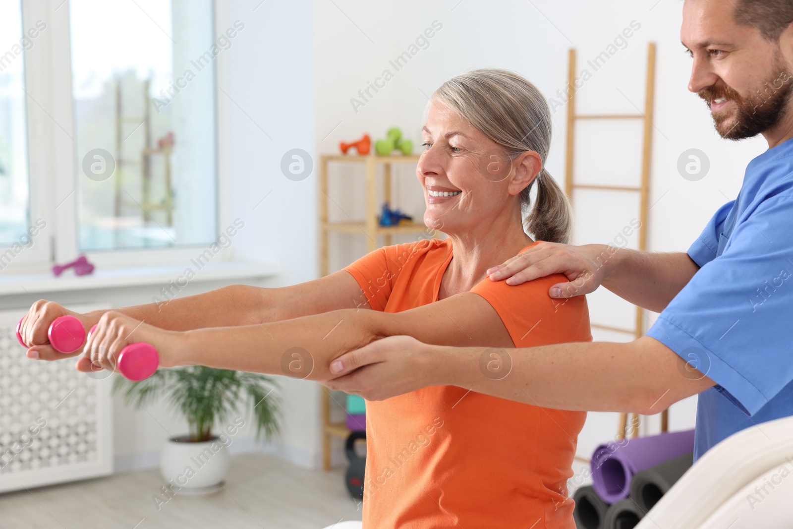 Photo of Senior patient exercising under physiotherapist supervision in rehabilitation center