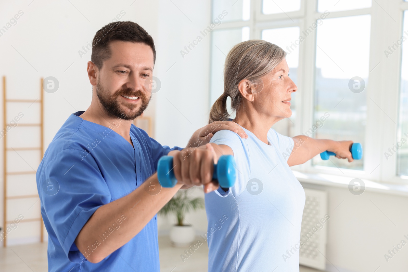 Photo of Senior patient exercising under physiotherapist supervision in rehabilitation center