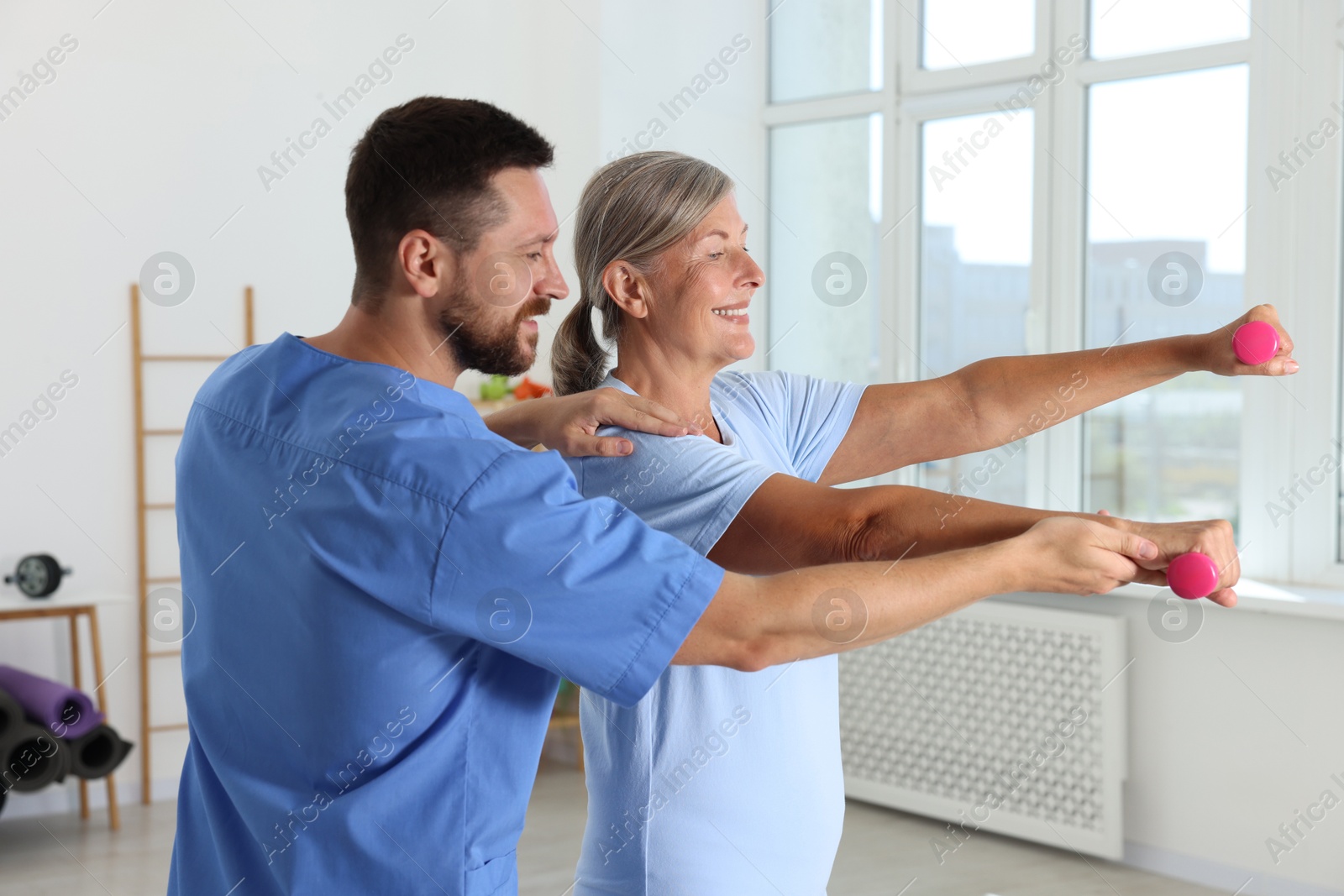 Photo of Senior patient exercising under physiotherapist supervision in rehabilitation center