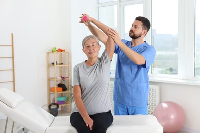 Photo of Senior patient exercising under physiotherapist supervision in rehabilitation center