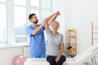 Photo of Senior patient exercising under physiotherapist supervision in rehabilitation center