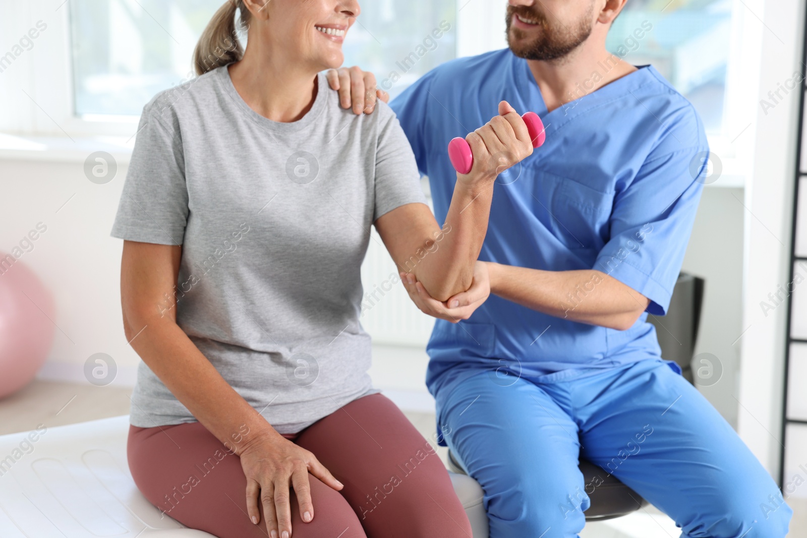 Photo of Senior patient exercising under physiotherapist supervision in rehabilitation center, closeup