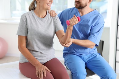 Senior patient exercising under physiotherapist supervision in rehabilitation center, closeup