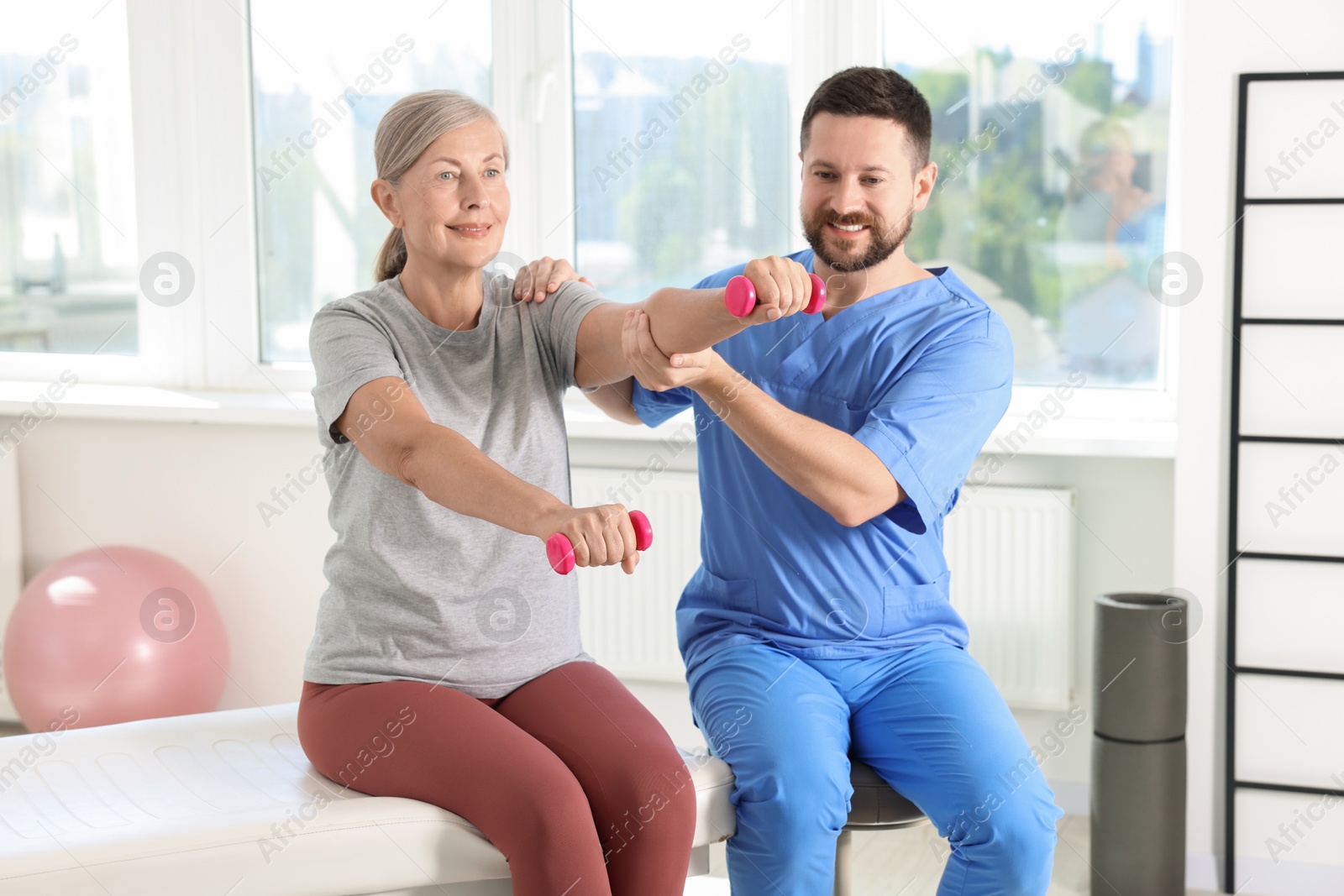 Photo of Senior patient exercising under physiotherapist supervision in rehabilitation center