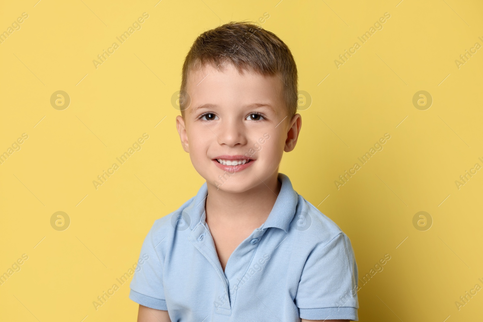 Photo of Portrait of cute little boy on yellow background